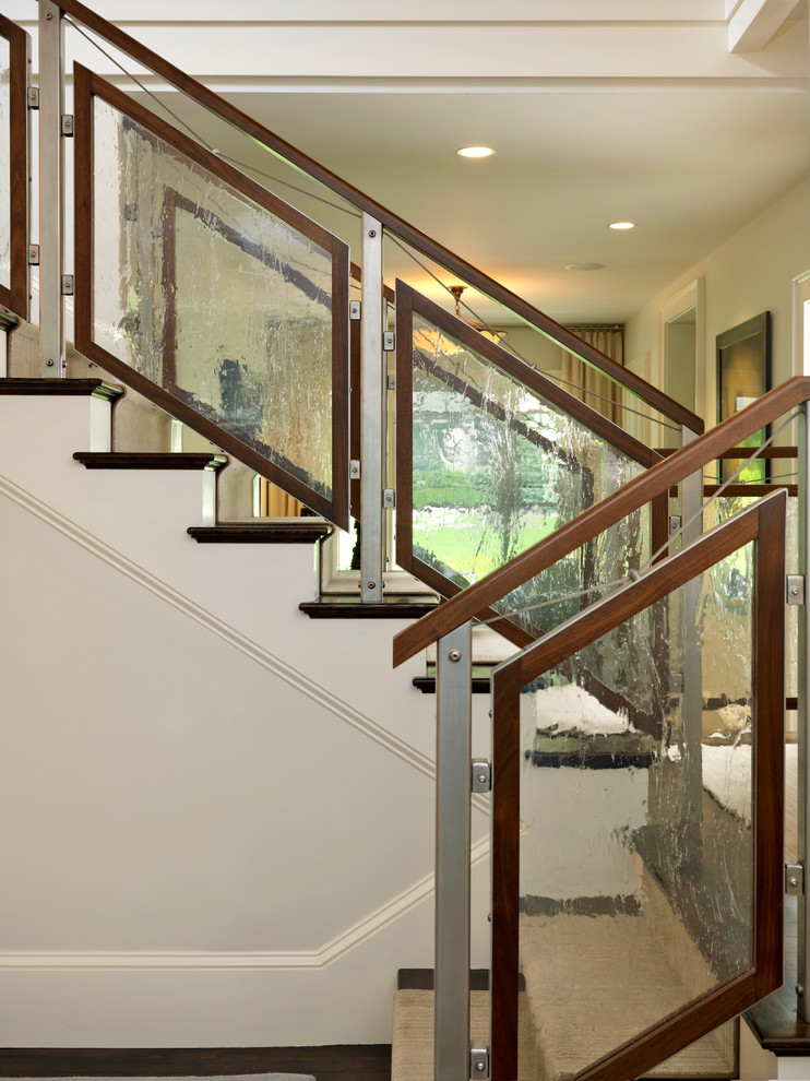 Cette image montre un escalier design avec des marches en bois et un garde-corps en verre.