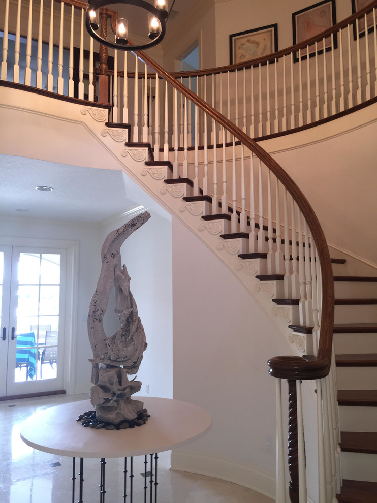 Beach style wooden curved staircase photo in Los Angeles with painted risers