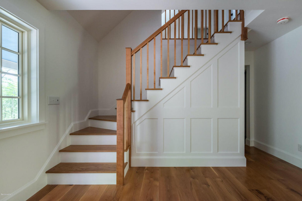 Idées déco pour un grand escalier peint classique en L avec des marches en bois et un garde-corps en bois.