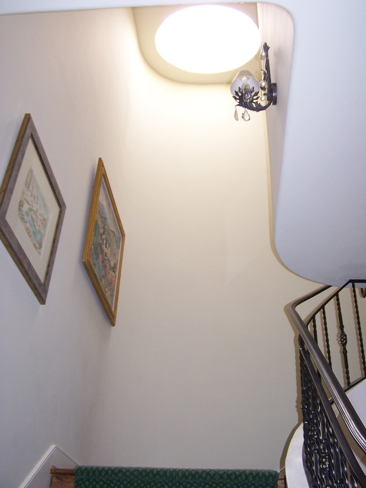 Idée de décoration pour un escalier courbe tradition de taille moyenne avec des marches en bois et des contremarches en bois.