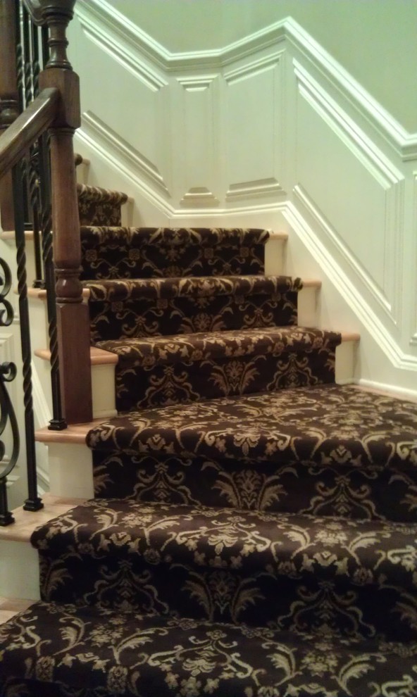 Inspiration pour un très grand escalier courbe traditionnel avec des marches en moquette et un garde-corps en matériaux mixtes.