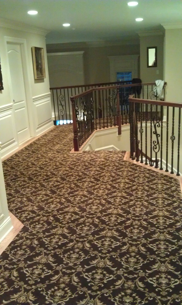 Cette image montre un très grand escalier courbe traditionnel avec des marches en moquette et un garde-corps en matériaux mixtes.