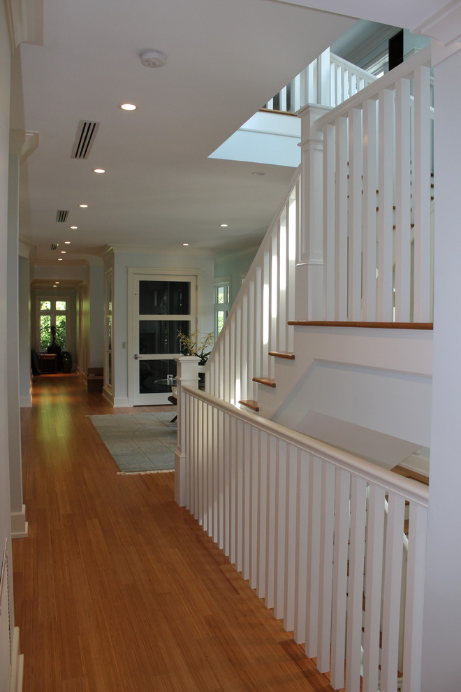 Свежая идея для дизайна: деревянная лестница в стиле неоклассика (современная классика) с деревянными ступенями и деревянными перилами - отличное фото интерьера