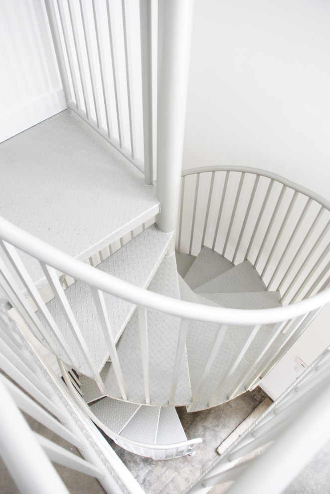 На фото: большая винтовая лестница в стиле модернизм с металлическими ступенями без подступенок с