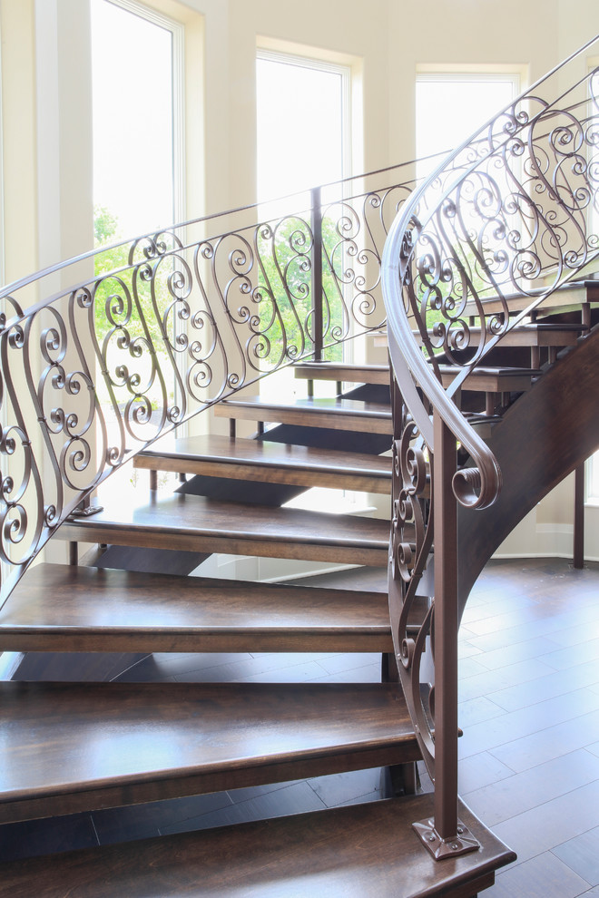 На фото: огромная изогнутая металлическая лестница в современном стиле с деревянными ступенями