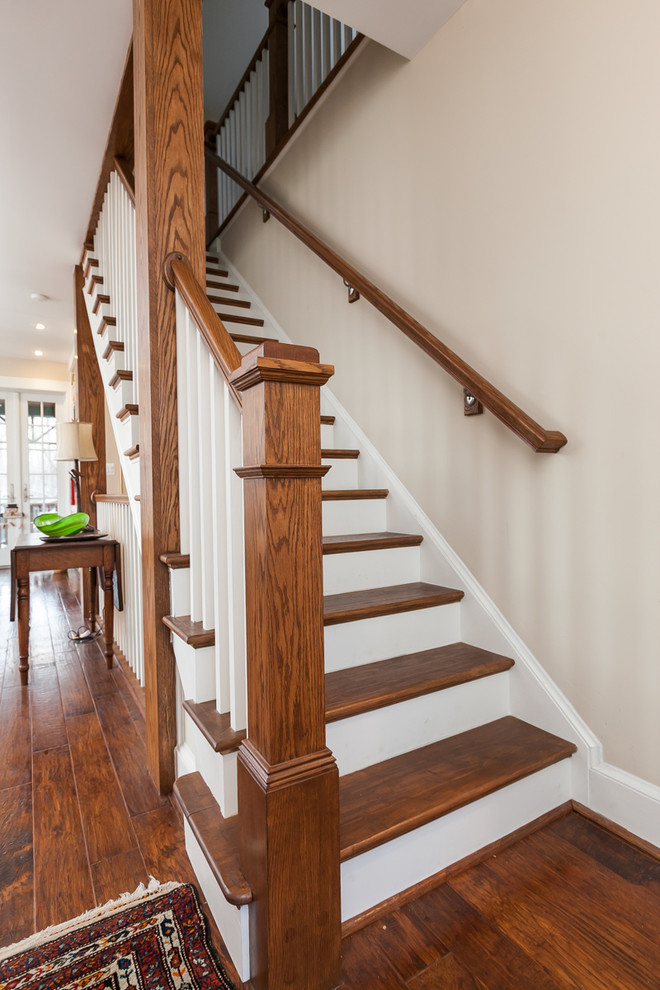 Photo of a large traditional wood straight staircase in Baltimore with painted wood risers and feature lighting.
