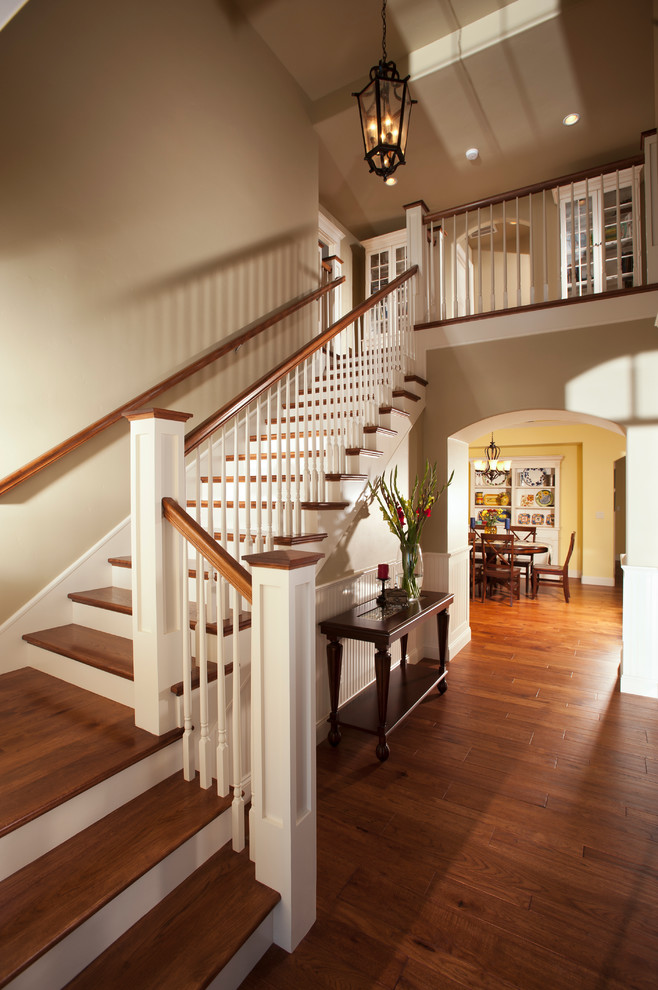 Aménagement d'un escalier peint classique en L avec des marches en bois et un garde-corps en bois.