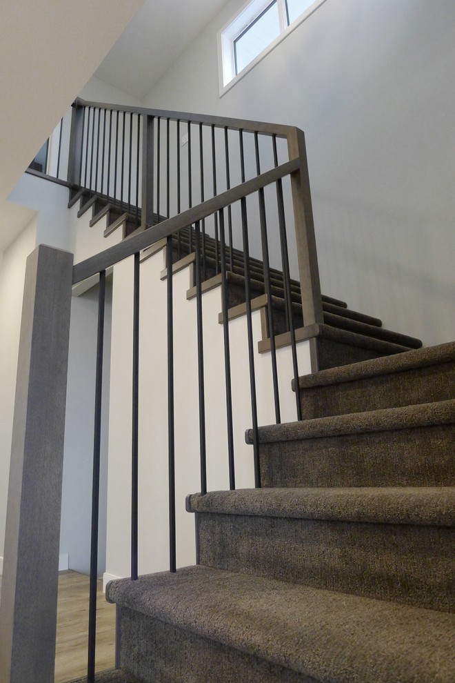 Foto de escalera en L contemporánea pequeña con escalones enmoquetados, contrahuellas enmoquetadas y barandilla de madera