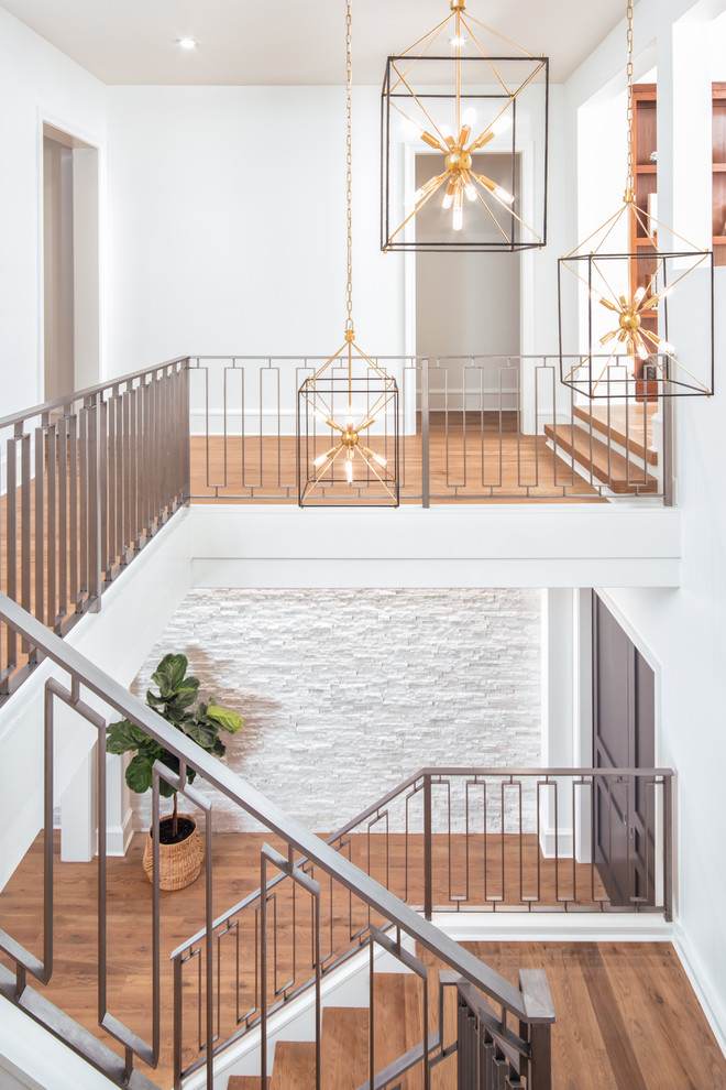 Источник вдохновения для домашнего уюта: огромная п-образная лестница в стиле неоклассика (современная классика) с деревянными ступенями