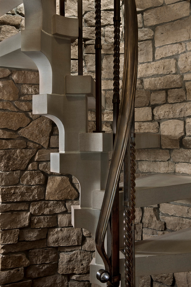 Inspiration pour un grand escalier hélicoïdal traditionnel en béton avec un garde-corps en métal et des contremarches en béton.