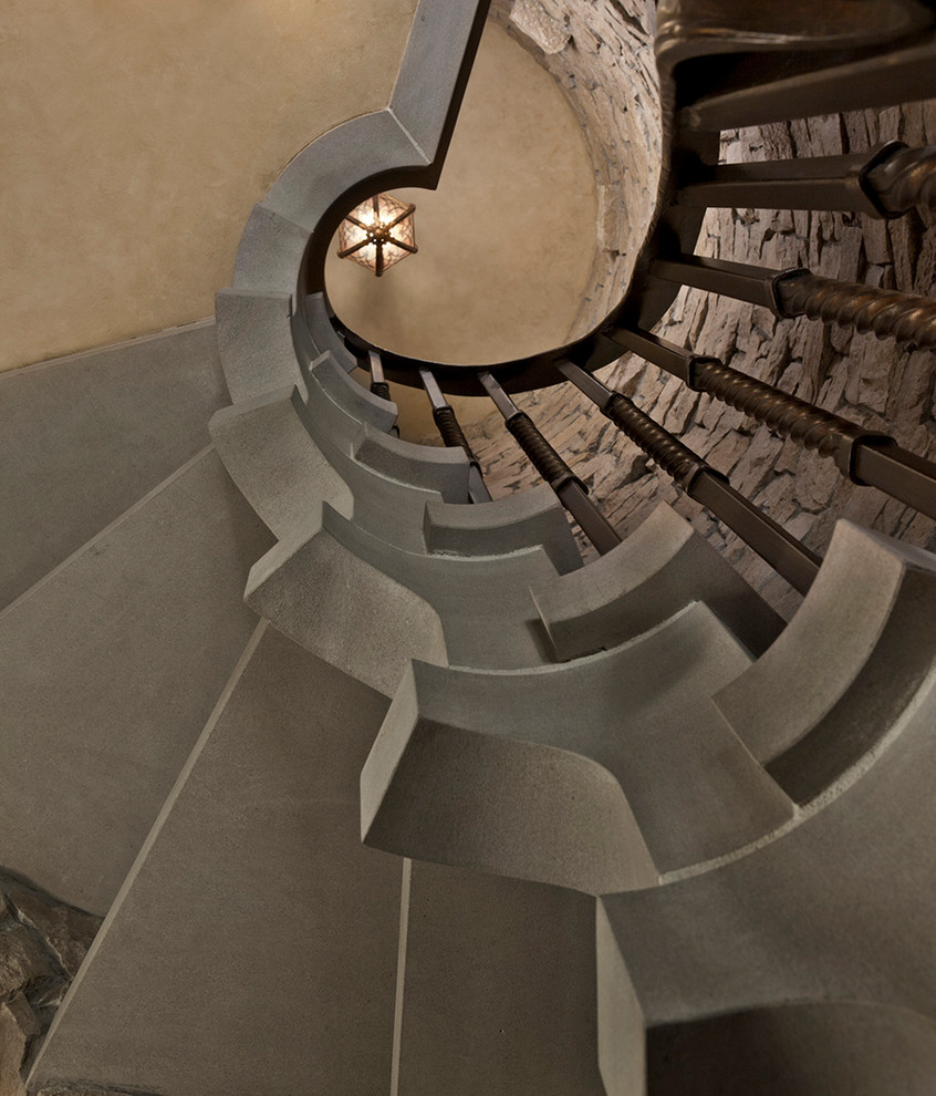 Стильный дизайн: большая винтовая лестница в классическом стиле с бетонными ступенями и металлическими перилами без подступенок - последний тренд