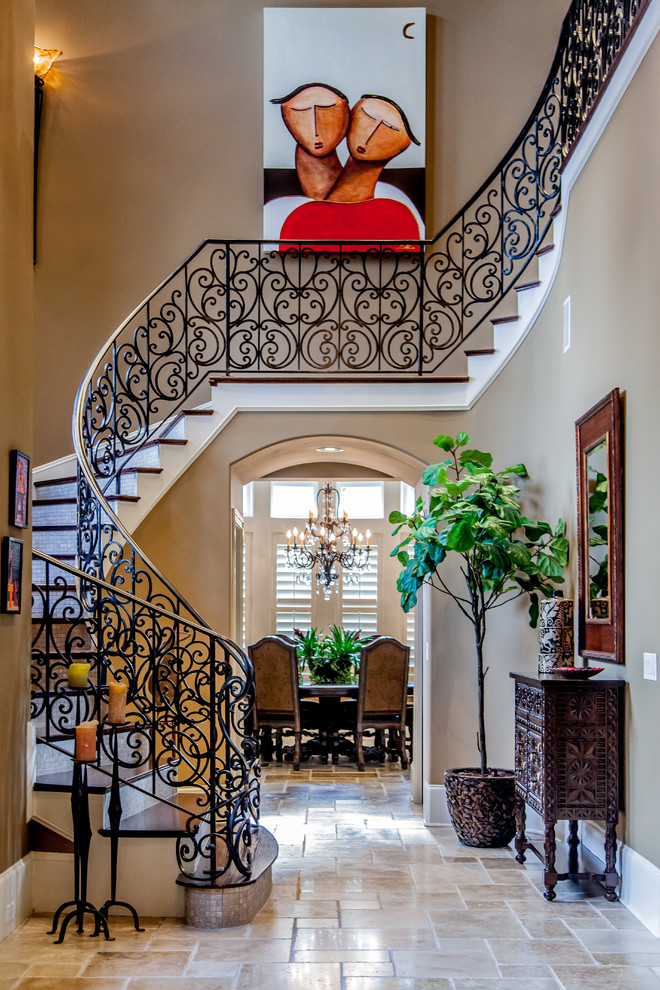 Источник вдохновения для домашнего уюта: большая изогнутая лестница в средиземноморском стиле с деревянными ступенями, металлическими перилами и подступенками из плитки
