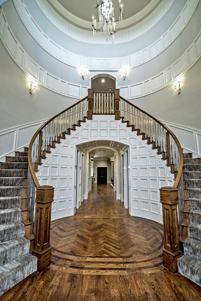 Exemple d'un très grand escalier courbe chic avec des marches en moquette, des contremarches en moquette et un garde-corps en matériaux mixtes.