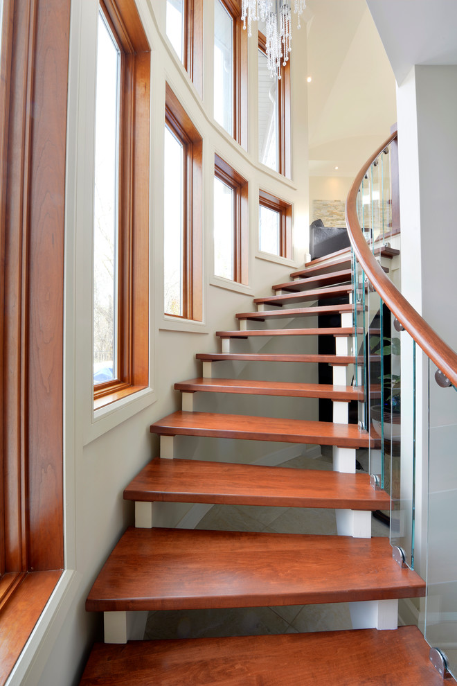 Photo of a contemporary wood curved staircase in Ottawa with open risers.
