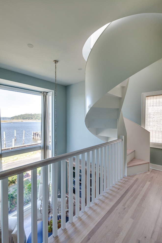 Cette image montre un escalier peint hélicoïdal marin avec des marches en bois.