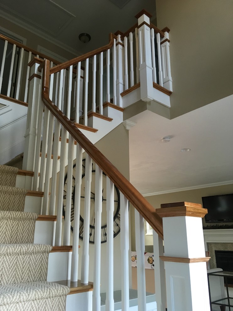 Cette image montre un grand escalier peint craftsman en L avec des marches en bois.