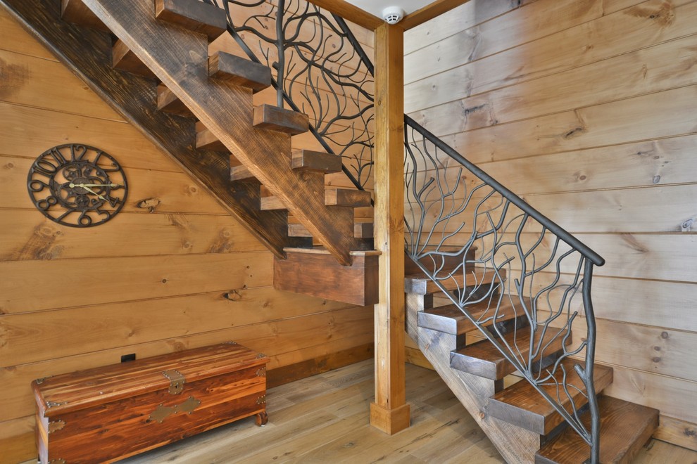 Idée de décoration pour un escalier sans contremarche chalet en L de taille moyenne avec des marches en bois et un garde-corps en métal.