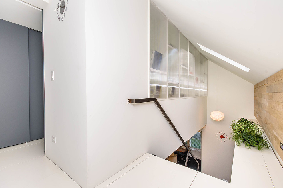 Ejemplo de escalera suspendida minimalista pequeña con escalones de madera y barandilla de metal