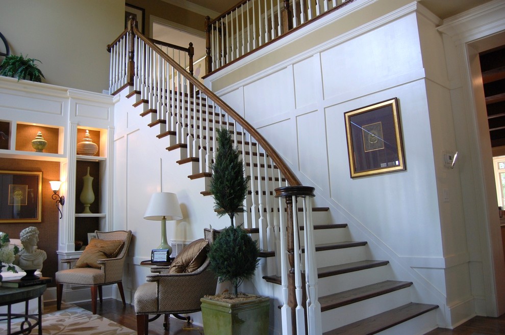 シャーロットにある高級な中くらいなトラディショナルスタイルのおしゃれな階段 (フローリングの蹴込み板、木材の手すり) の写真