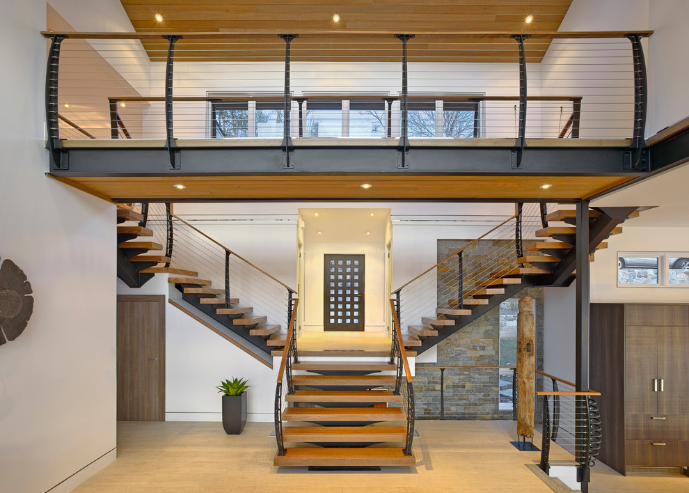 Стильный дизайн: лестница на больцах в стиле модернизм с деревянными ступенями и перилами из тросов без подступенок - последний тренд