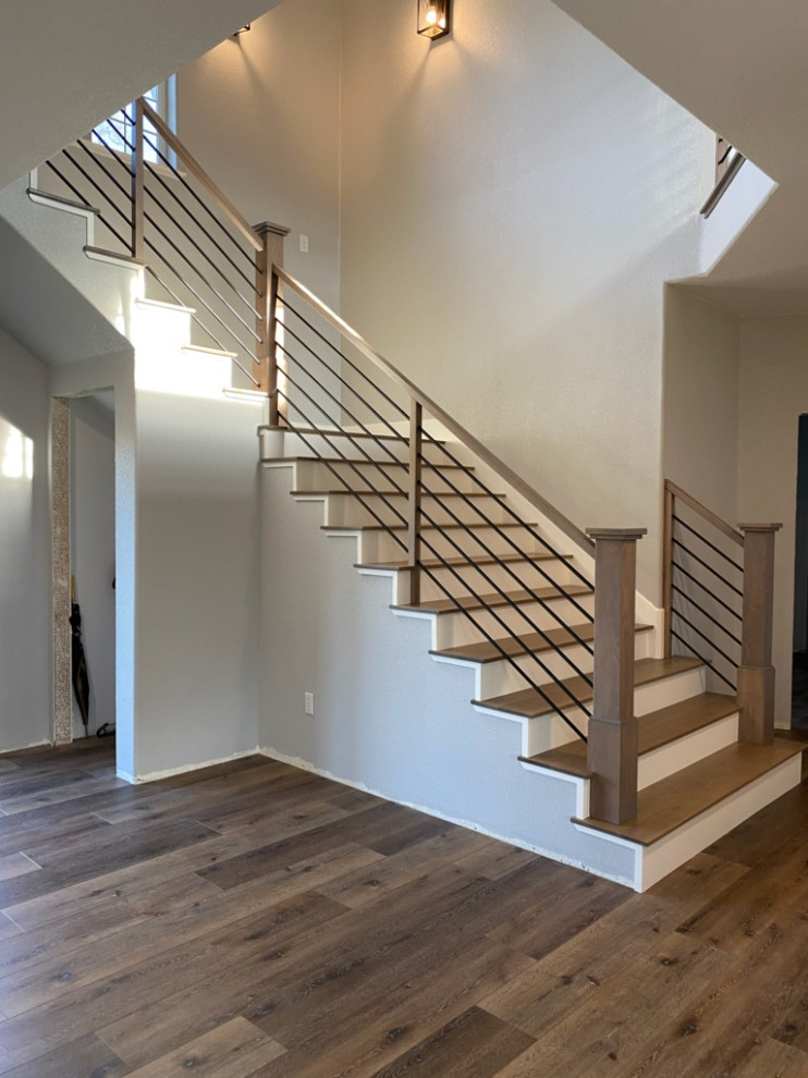 Пример оригинального дизайна: большая угловая лестница в современном стиле с деревянными ступенями, крашенными деревянными подступенками и перилами из смешанных материалов