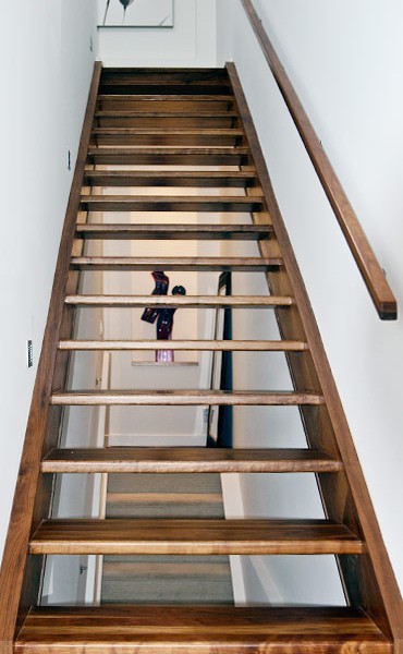 Ispirazione per una scala a rampa dritta minimalista di medie dimensioni con pedata in legno e nessuna alzata