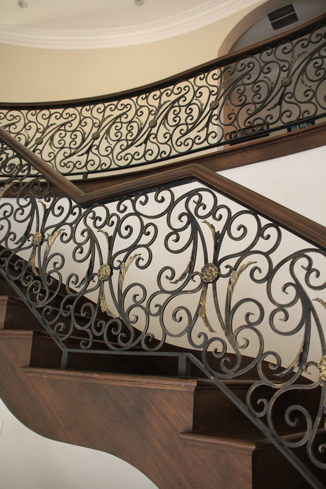 Example of a large tuscan wooden curved staircase design in Chicago with wooden risers