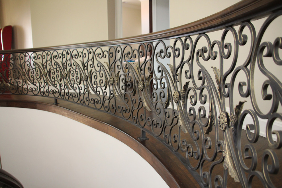 Large mediterranean wood curved staircase in Chicago with wood risers.