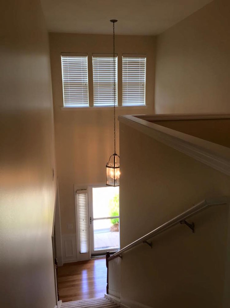 This is an example of a medium sized traditional carpeted straight wood railing staircase in Charlotte with carpeted risers.