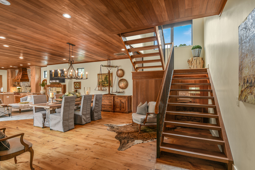 Imagen de escalera suspendida de estilo de casa de campo grande sin contrahuella con escalones de madera y barandilla de metal
