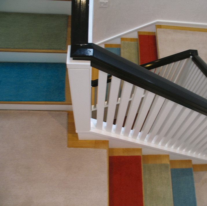 Пример оригинального дизайна: прямая лестница среднего размера в стиле модернизм с ступенями с ковровым покрытием и крашенными деревянными подступенками