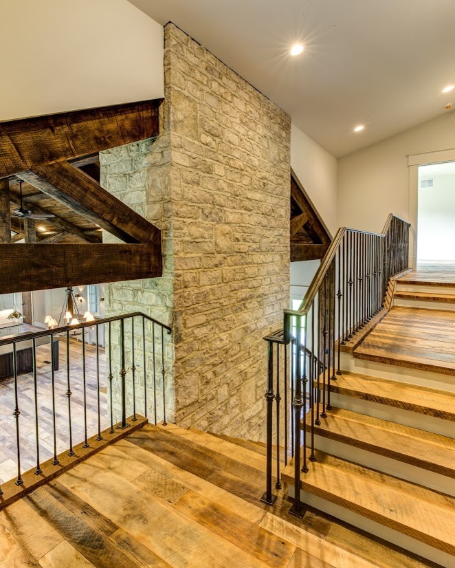 Ejemplo de escalera en U de estilo de casa de campo grande con escalones de madera y contrahuellas de madera pintada