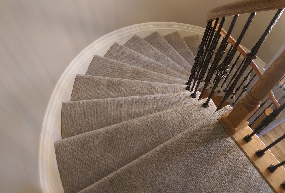 Пример оригинального дизайна: изогнутая лестница среднего размера с ступенями с ковровым покрытием и ковровыми подступенками