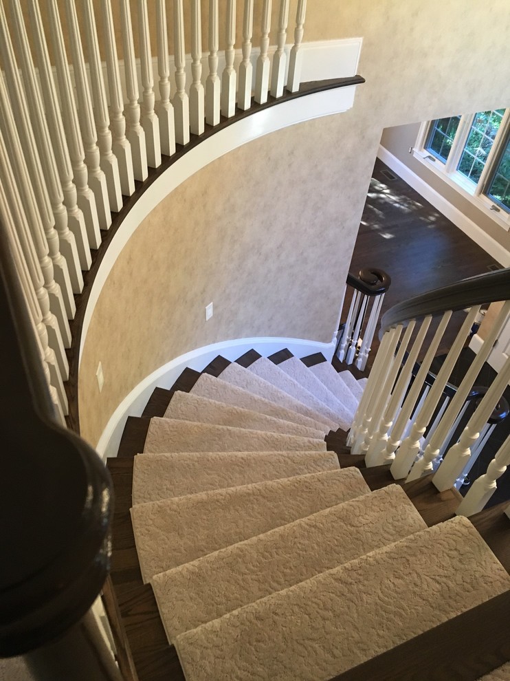 Diseño de escalera curva tradicional de tamaño medio con escalones de madera, contrahuellas de madera y barandilla de madera
