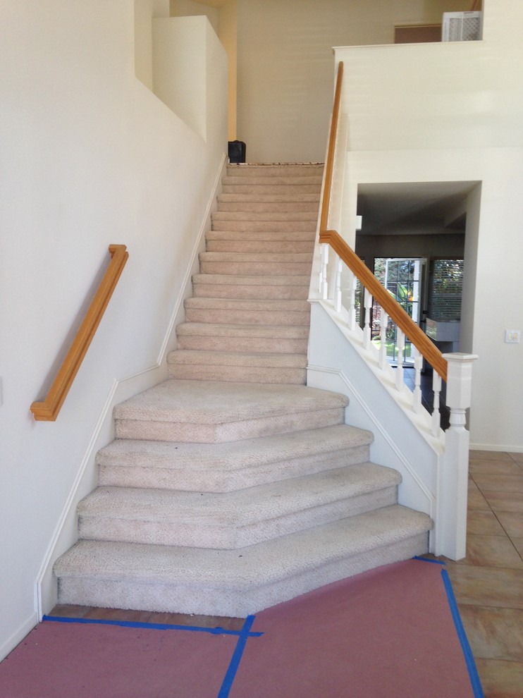 На фото: большая угловая лестница в классическом стиле с ступенями с ковровым покрытием и ковровыми подступенками