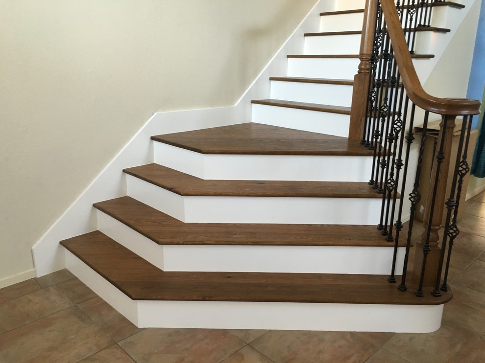 Large classic wood l-shaped staircase in Orange County with painted wood risers.