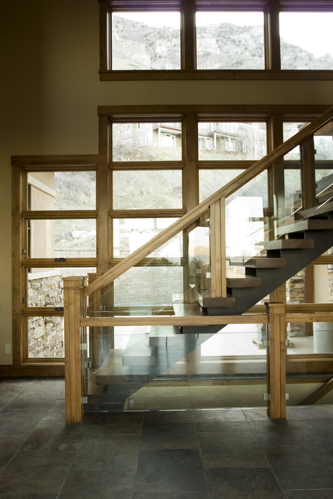 Idée de décoration pour un escalier sans contremarche design avec des marches en bois et un garde-corps en verre.