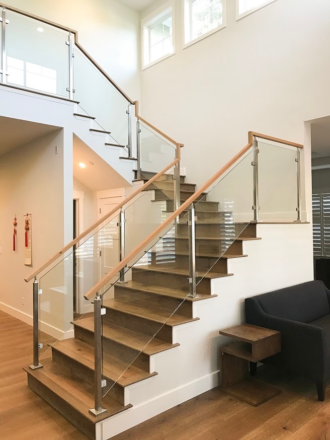 Idées déco pour un grand escalier contemporain en U avec des marches en bois, des contremarches en bois et un garde-corps en verre.