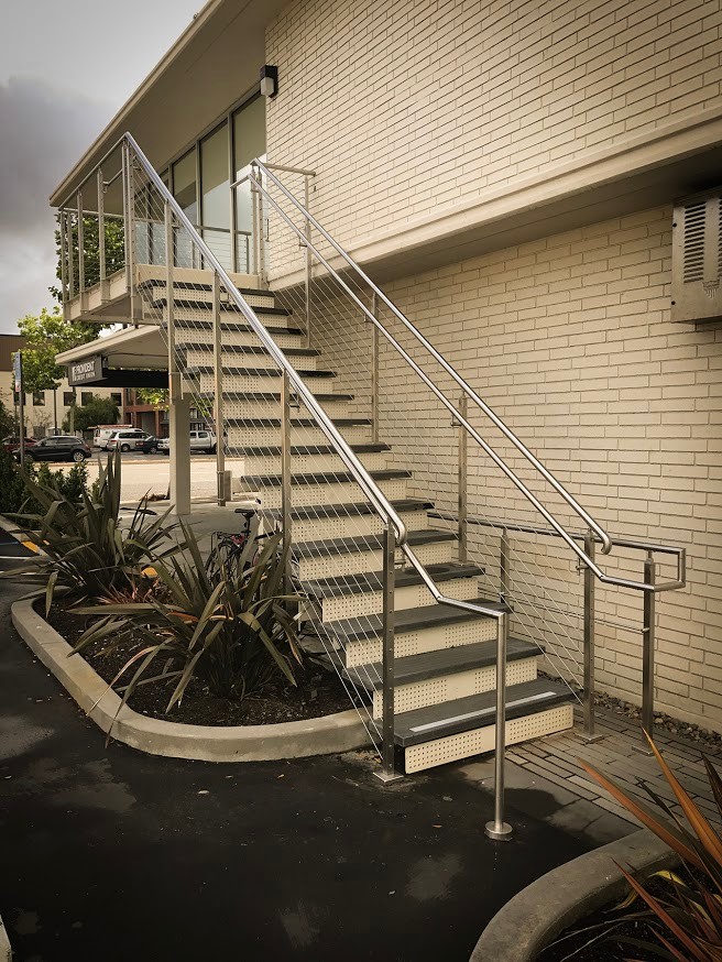 Inspiration för stora moderna raka trappor, med sättsteg i metall och kabelräcke