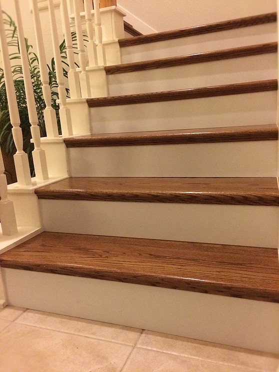 Diseño de escalera curva clásica de tamaño medio con escalones de madera, contrahuellas de madera pintada y barandilla de madera
