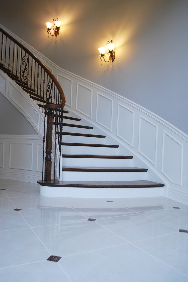Inspiration for a large classic wood curved staircase in Chicago with painted wood risers.
