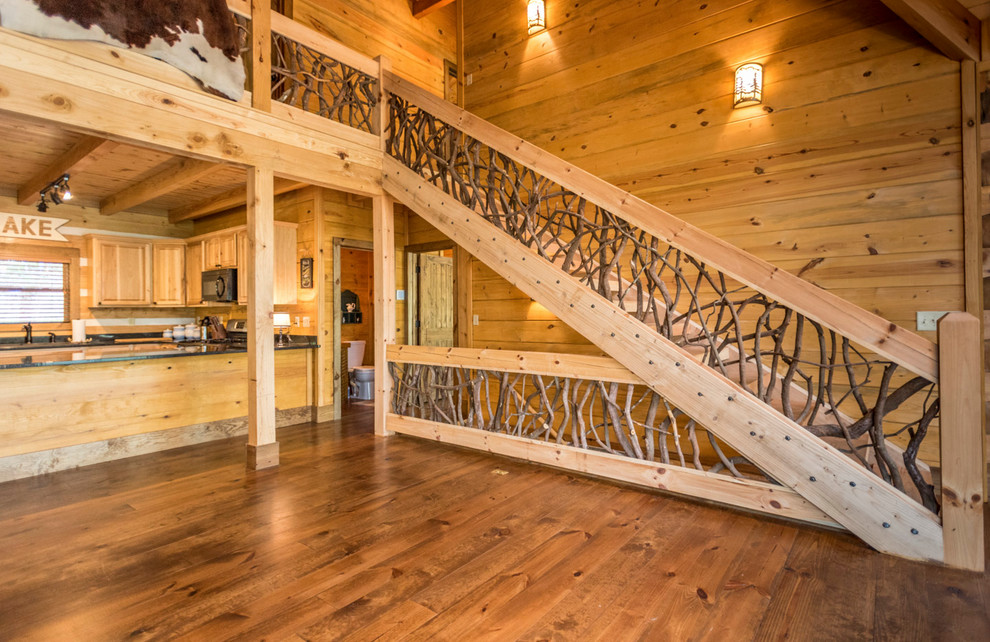 アトランタにある高級な広いラスティックスタイルのおしゃれな階段 (木材の手すり) の写真