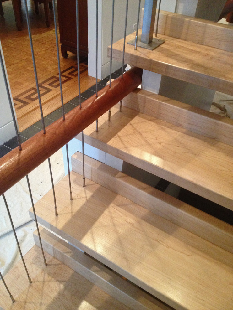 Esempio di una scala a rampa dritta minimal di medie dimensioni con pedata in legno e nessuna alzata