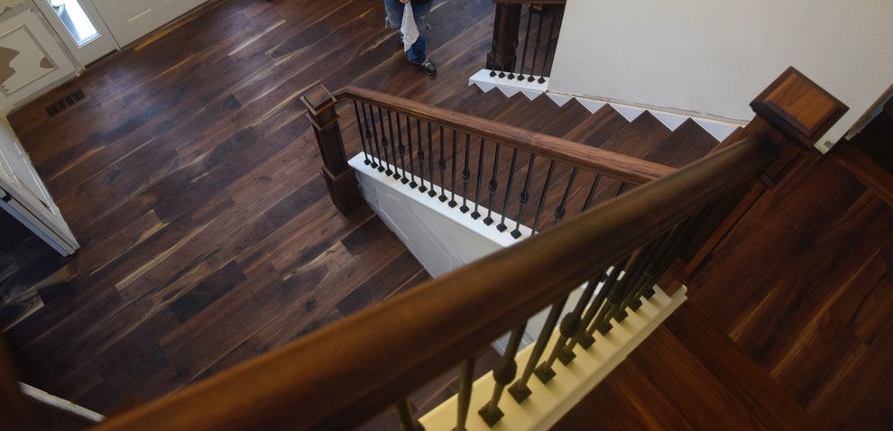 ワシントンD.C.にある広いトランジショナルスタイルのおしゃれなかね折れ階段 (木の蹴込み板、混合材の手すり) の写真