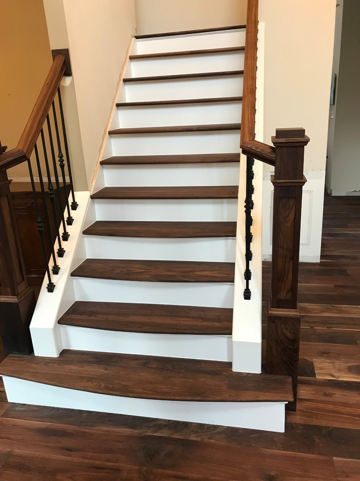 ワシントンD.C.にある広いトランジショナルスタイルのおしゃれなかね折れ階段 (木の蹴込み板、混合材の手すり) の写真