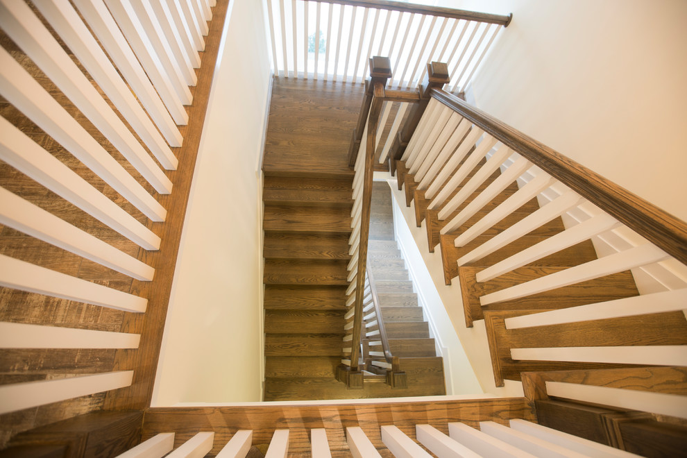 Foto de escalera suspendida clásica con escalones de madera, contrahuellas de madera y barandilla de madera