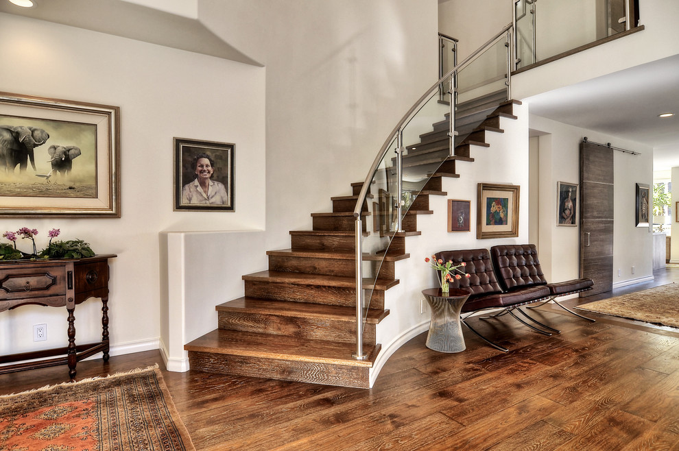 Example of a mid-sized eclectic wooden curved metal railing staircase design in Orange County with wooden risers