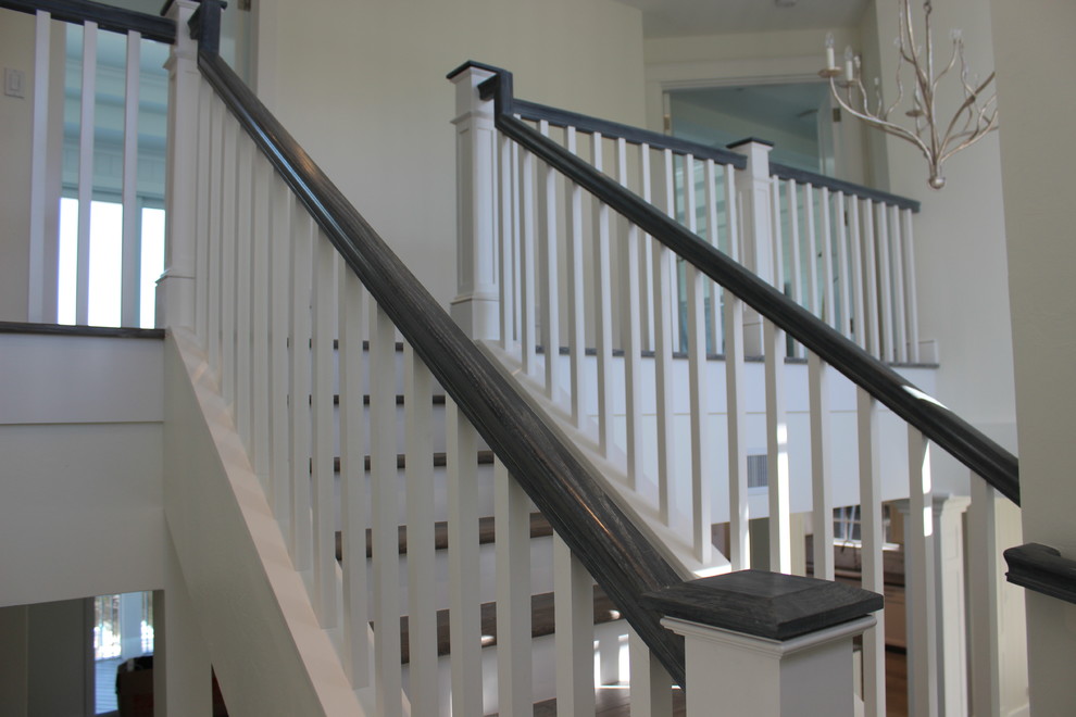 This is an example of a large coastal wood railing staircase in Other.
