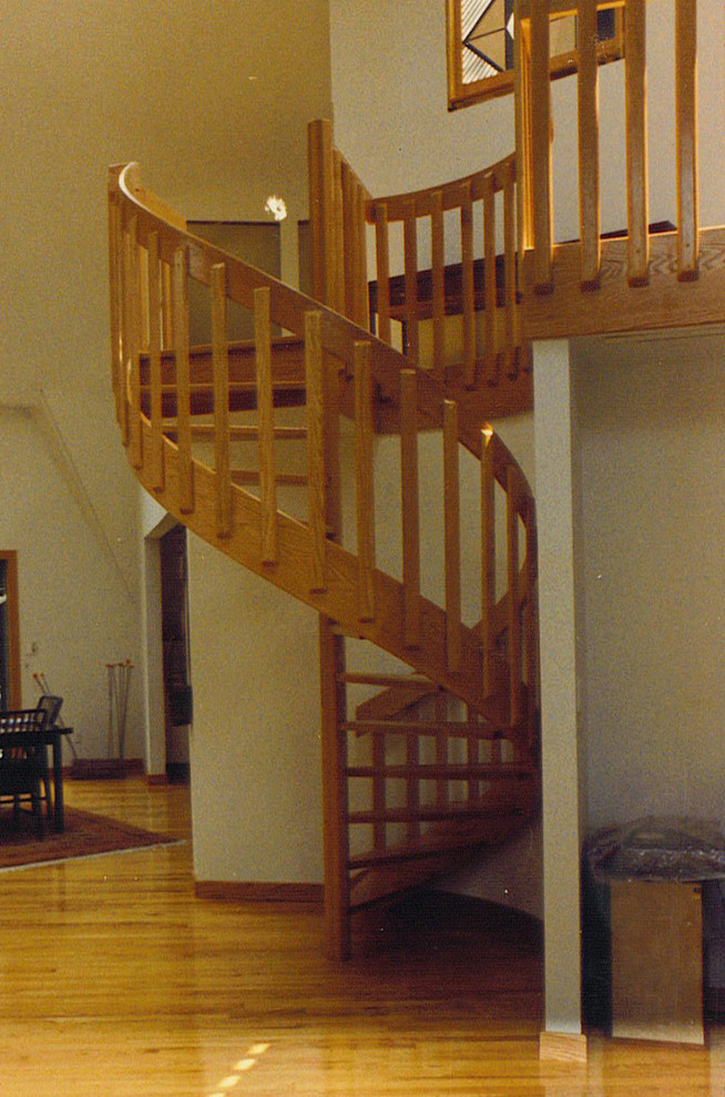 Small wood spiral staircase in New York with open risers.