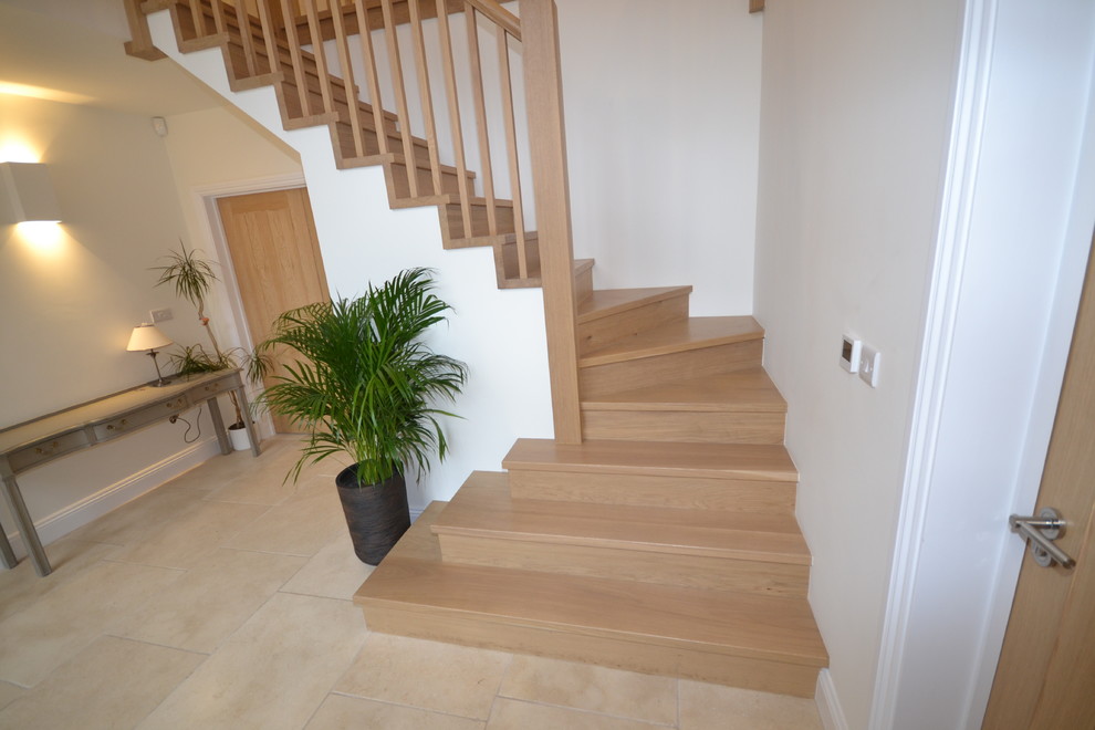 Cette photo montre un grand escalier moderne en L avec des marches en bois.